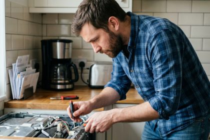 Homme en réparation d'appareil électroménager dans une cuisine moderne